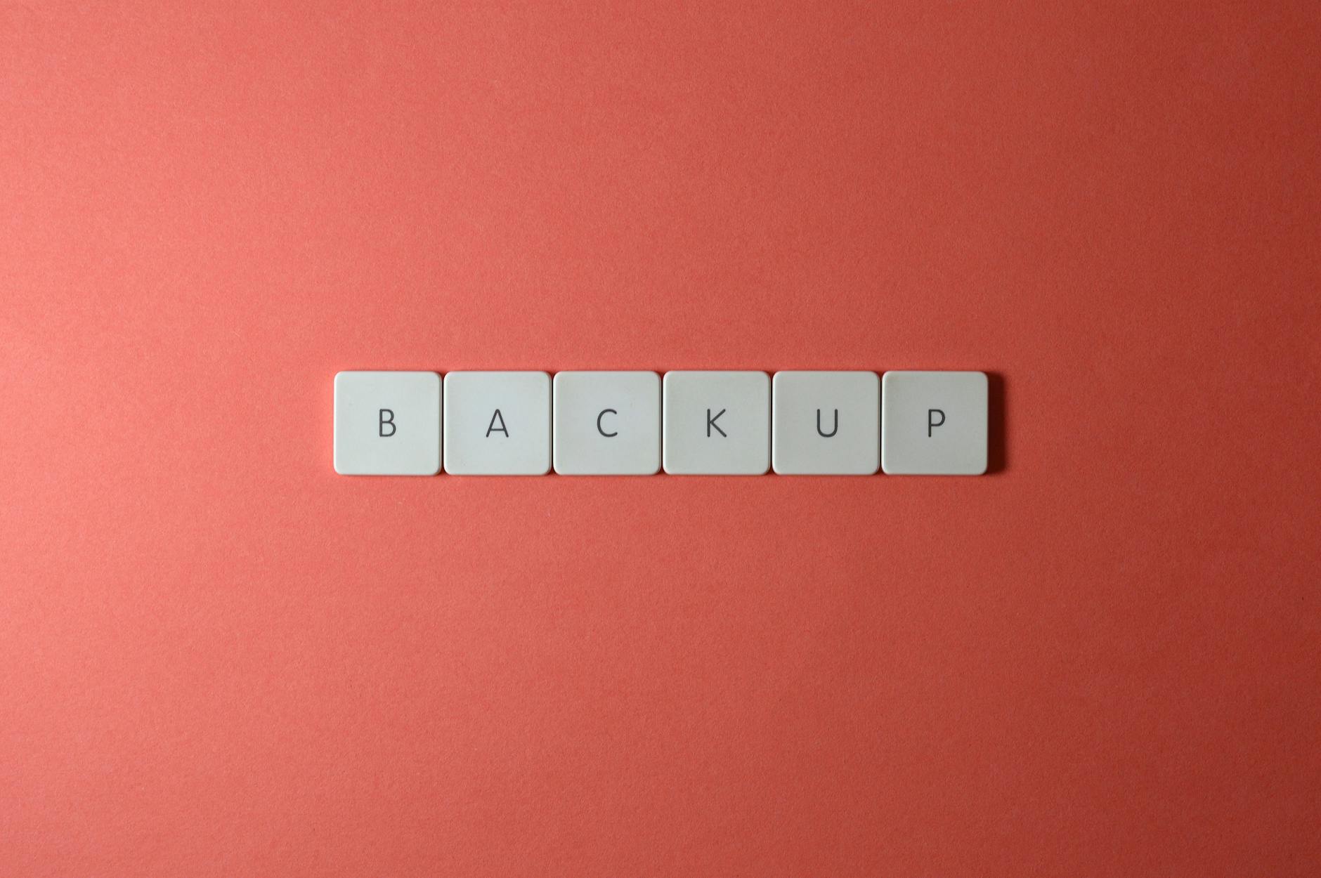 Klawiatura z klawiszami układającymi się w napis BACKUP na koralowym tle
