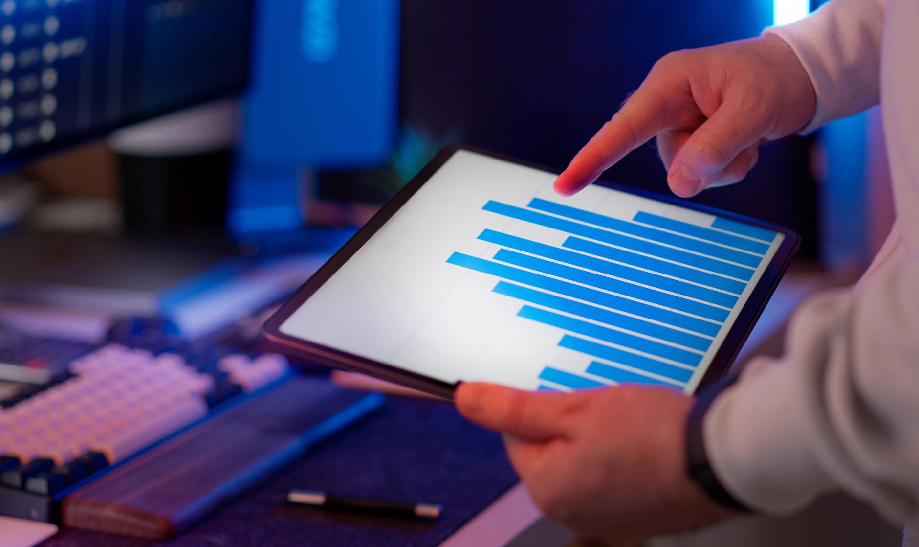 Specjalista IT analizuje wykres słupkowy KPI DevOps na tablecie w biurze